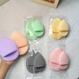 Dettaglio di spugne detergenti colorate a goccia con fessure per le dita nel pack
