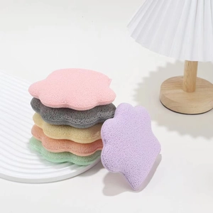 Cloud-shaped colorful compressed wood pulp facial cleansing sponges in a minimalist stack