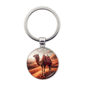 Detail of silver desert camel keychain with glass dome pendant showing middle east design