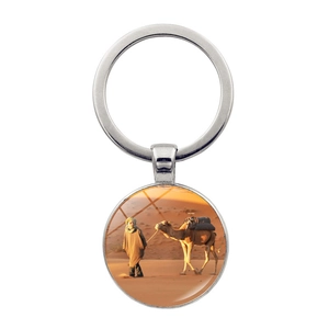 Polished metal keychain featuring a desert camel sunset scene inside a glass dome pendant
