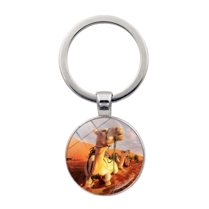 Detail of silver alloy keychain with glass dome desert camel photo pendant on white background