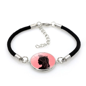 Close-up of woven bracelet with pink crown pendant and adjustable silver clasp