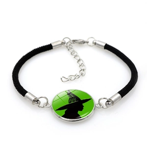 Detail of woven bracelet featuring a green Elphaba witch silhouette glass cabochon