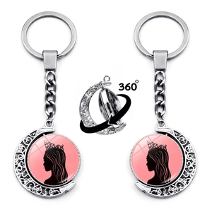 Detail of 360-degree rotating moon keychain with Elphaba and Glinda silhouettes
