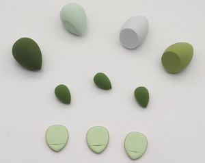 Macro detail of 9-piece green makeup sponge set including mini puffs and blenders