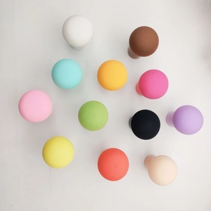 Detailed top view of 12 multi-colored mushroom head makeup sponges on white background