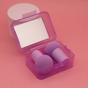 Macro detail of purple mushroom head makeup sponges in a storage case with mirror