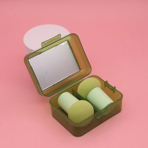 Green mushroom makeup sponges in a dark green case with a built-in mirror and pink base