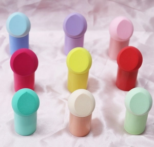 Set of 9 colorful makeup sponges with bases on a pink satin background