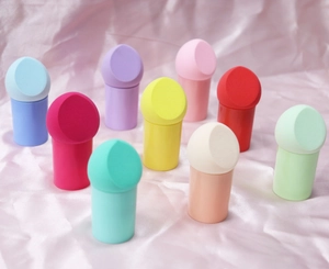 Detail of colorful mushroom head makeup sponges with storage bases on pink silk