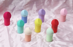 Macro shot of 9 colorful slanted makeup sponges with matching storage stands on silk