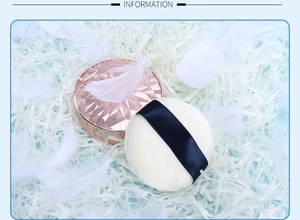 Close-up of rose gold quilted cushion compact with soft white puff on blue background
