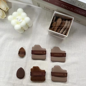Macro view of 6-piece chocolate makeup puff set showing various shapes and soft textures