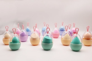 Close-up of colorful makeup sponges in egg-shaped cases with hooks for hanging and storage