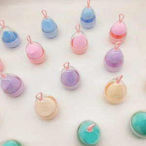 Macro shot of colorful teardrop makeup sponges in portable egg-shaped clear plastic cases