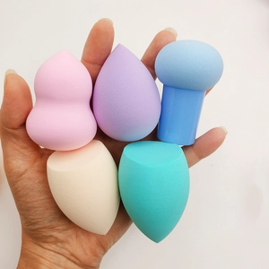 Detailed close-up of a 5-piece makeup sponge set with various shapes and colors held in hand