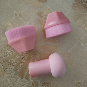 Close-up of pink hexagonal foundation brushes and a soft mushroom sponge set