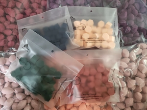 Detail view of multi-color geometric makeup sponges in ALYAN branded resealable bags