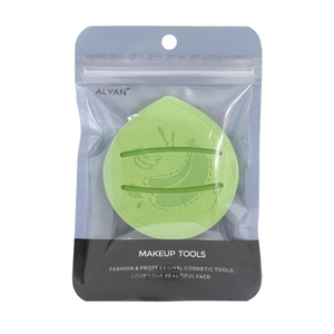 Detail of light green heart-shaped makeup sponge with finger strap in branded packaging