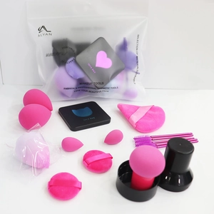Détail du kit de maquillage avec éponges, pinceaux et houppettes dans un sac ALYAN