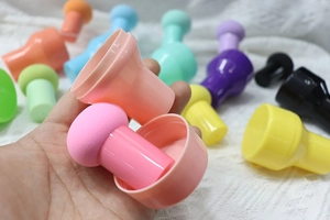Détail de plusieurs éponges de maquillage tête de champignon colorées avec poignées