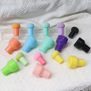 Lot d'éponges à maquillage champignon colorées avec manches sur fond texturé blanc