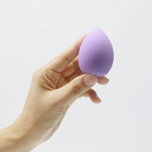Close-up of a soft purple teardrop makeup sponge held in hand for detail texture