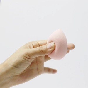 Detail showing the ultra-soft pink teardrop makeup sponge with high elasticity and fine texture