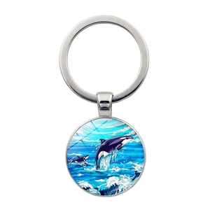 Detailed close-up of a silver keychain featuring a round glass orca whale ocean pendant