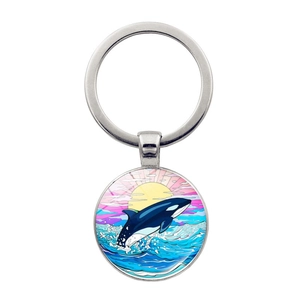 Detailed view of metal keychain featuring a colorful orca jumping over ocean waves