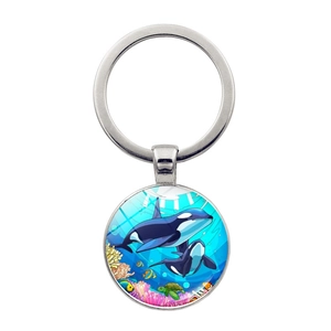 Macro detail of silver orca ocean pendant with colorful coral and sea turtle illustration