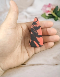 Close-up of dual-tone marble makeup sponge with tapered tip for precise application