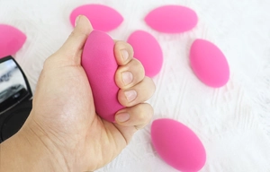 Detail showing high flexibility and soft texture of a rose pink teardrop beauty sponge