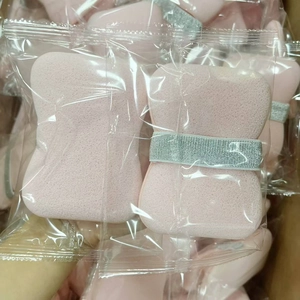 Close-up of bulk pink bow-shaped soap sponges in individual clear plastic packaging