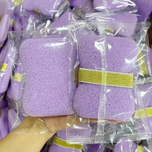 Detail of purple soft sponge face puff in individual plastic packaging with gold band