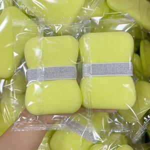 Close-up of bright yellow soft foaming sponge with elastic strap in clear packaging