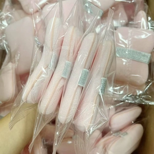 Close-up of pink soft sponge puff in clear pouch with grey finger strap for face cleansing