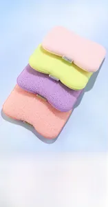 Detail of four colorful soft bath sponges with honeycomb texture and glitter trim