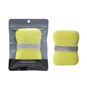 Detail of yellow makeup sponge with silver band and transparent branded packaging pouch