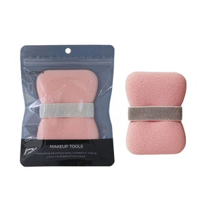 Detail of pink exfoliating bath sponge with elastic strap and retail packaging