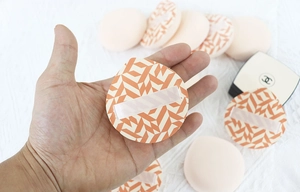 Detail eines weichen Rubycell-Kissens mit orangefarbenem Muster und lila Halteband