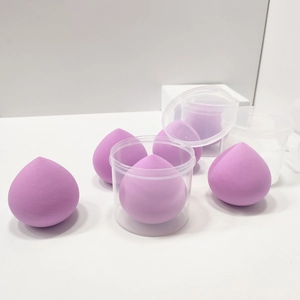 Macro shot of purple teardrop makeup sponges in a clear plastic storage container