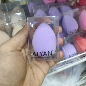 Detail of drop-shaped makeup sponge in transparent box and soft macaron colors
