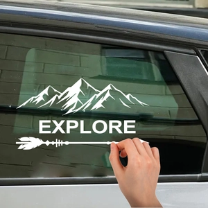 Applying a white mountain silhouette and Explore arrow vinyl decal to a car side window