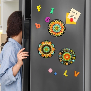 Detailed view of colorful Mandala fridge magnets on dark grey metal surface
