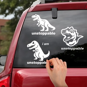 Applying white vinyl dinosaur car stickers featuring unstoppable motivational text to red glass