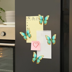 Set of four green butterfly magnetic fridge stickers with gold edges on a black background