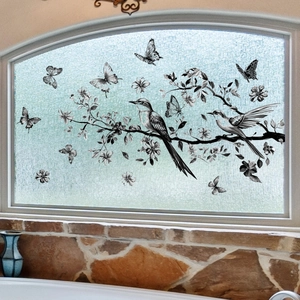 Decorative window sticker with birds and butterflies on branches on frosted glass