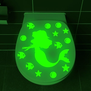 Luminous green mermaid and sea stars decals glowing in the dark on a toilet lid