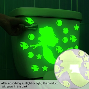 Luminous mermaid wall stickers showing green glow on toilet tank in dark bathroom